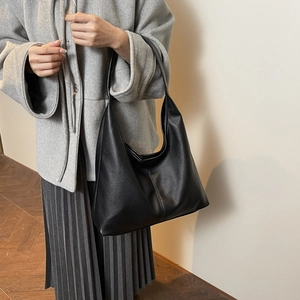 Detail of black pebbled leather tote bag with vertical stitching for commuter styling