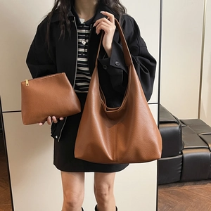 Detail showing brown lychee grain leather tote bag set with golden metal zippers