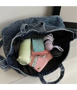 Intérieur spacieux du cabas en denim lavé avec rangement organisé pour objets du quotidien