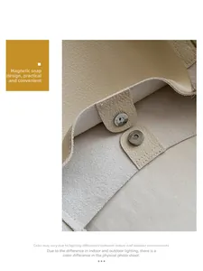 Detail view of the magnetic closure on a beige soft leather tote bag for women