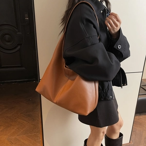 Detail of tan hobo shoulder bag showing natural leather texture and slouchy drape