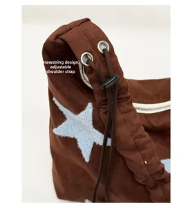 Detail of adjustable drawstring and metal eyelets on a brown plush star shoulder bag