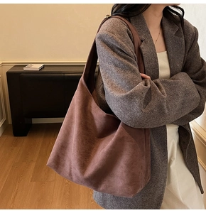 Detail view of large dark brown suede tote bag showing premium matte texture and drape