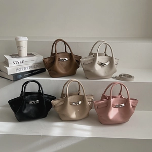 Détail de cinq sacs seau texturés en marron, beige, noir, abricot et rose avec bandoulières