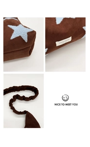 Macro detail of brown star-pattern suede bag featuring ruffled strap and brand woven label