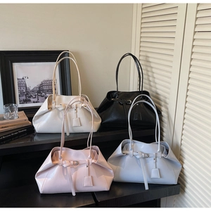 Detailed display of four large vintage shoulder bags in white, black, pink, and light blue