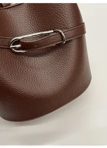 Détail du sac seau en cuir marron foncé avec fermoir en métal argenté brillant