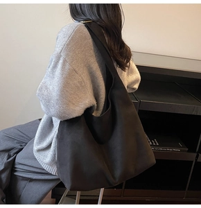 Minimalist black matte suede tote bag on model's shoulder for casual daily commute use