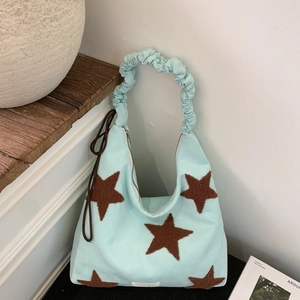 Detail of light blue star tote bag with ruffled handles and brown star patches