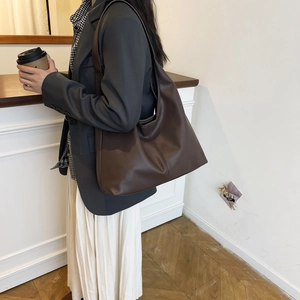 Close-up of a large dark brown faux leather hobo shoulder bag with textured finish