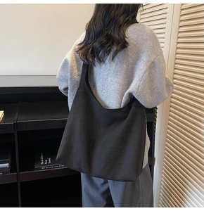 Minimalist black oversized suede tote bag shown on model for a chic urban aesthetic