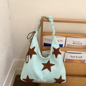 Detail of mint green hobo bag with brown plush stars and ruched shoulder strap