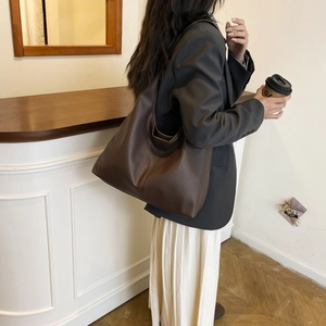 Detail of soft dark brown pebble leather shoulder bag for a minimalist commuter style