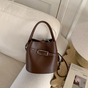 Détail du sac seau en cuir marron à motif litchi avec boucle argentée et poignée