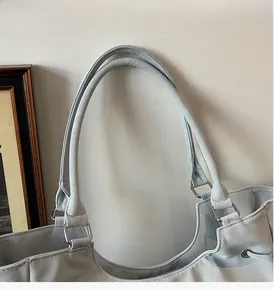 Close-up of durable round handles and silver metal hardware on a nylon tote bag