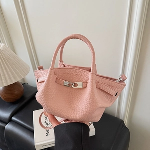 Détail du sac seau rose avec texture litchi, fermoir rotatif argenté et poignée