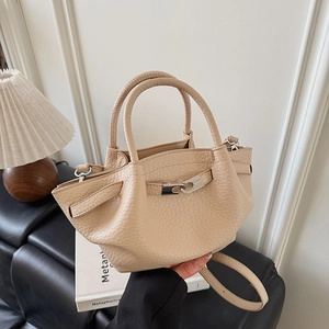Gros plan détaillé du sac seau abricot avec texture grainée et boucle argentée