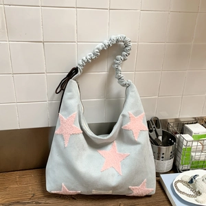 Detailed close-up of light blue star tote bag with pink plush patches and ruched handles