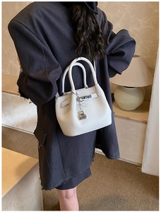 Détail du sac à main en cuir grainé blanc avec fermoir en métal et charm en forme de cœur