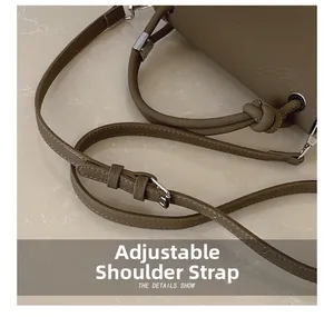 Macro detail of adjustable leather shoulder strap with metal buckle on brown tote bag