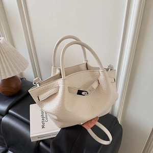 Détail d'un sac à main en cuir grainé crème avec fermoir argenté et plis élégants
