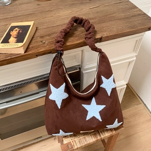 Detail of star patchwork on brown suede hobo bag with a ruched cloud shoulder strap