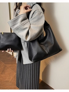 Black pebbled leather tote bag and zipper pouch set worn by model for daily commute