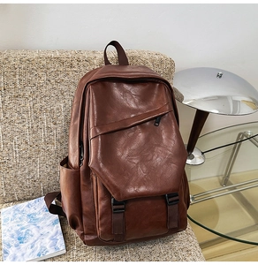 Detailed close-up of brown leather backpack on a sofa with vintage buckle and zipper features