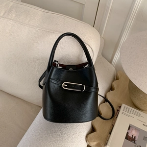Détail du sac seau en cuir grainé noir avec boucle argentée et doublure intérieure rouge