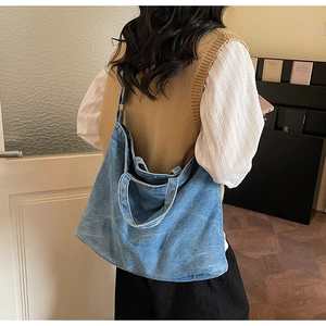 Rear view of a model carrying a vintage light blue denim tote bag for daily commute