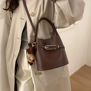 Détail du sac seau marron grainé avec boucle argentée et pendentif ours mignon