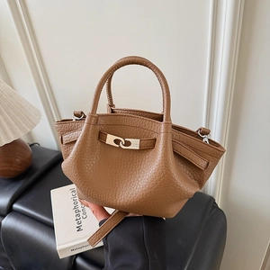 Gros plan d'un sac seau en cuir grainé marron avec boucle en métal argenté et plis