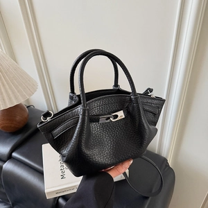 Détails du cuir grainé noir et de la boucle argentée sur le sac à main de style seau
