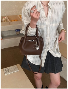 Détail du sac seau en cuir grainé marron foncé avec fermoir rotatif argenté et cadenas