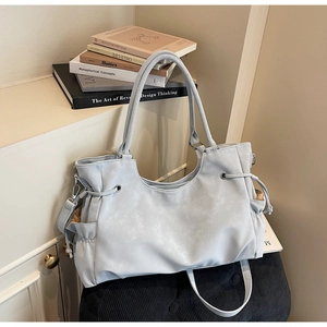Close-up of light blue tote bag side drawstring detail and soft PU leather texture
