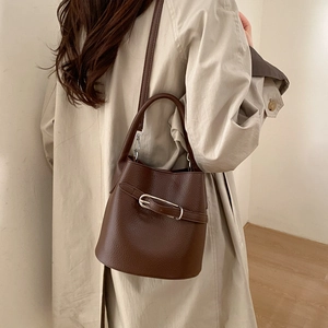 Vue détaillée du sac seau marron foncé en cuir grainé avec boucle en métal élégante