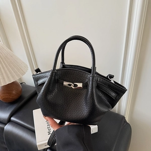 Détail du sac seau en cuir noir grainé avec fermoir métallique argenté élégant et finitions