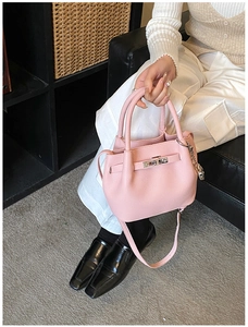 Détail du sac seau en cuir litchi rose avec fermoir en métal et bandoulière réglable