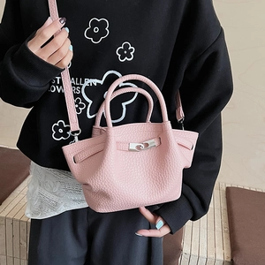 Détail de la texture cuir grainé et du fermoir en métal argenté du sac seau rose