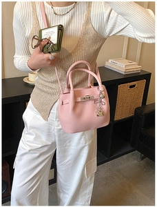 Détail du sac seau rose avec texture cuir, pendentif cœur et fermoir en métal doré