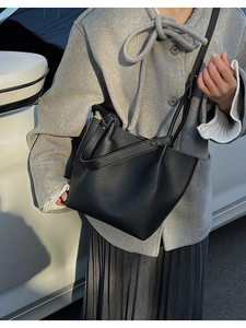 Detailed texture of black lychee grain leather on a stylish commuter bucket bag