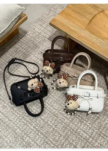 Detailed set of four mini crossbody bags in various colors with cute bear pendants
