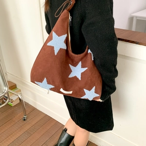 Detail of suede tote bag with plush blue star pattern and adjustable strap tie