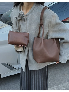 Close-up of brown pebbled leather tote and matching pouch set with long shoulder straps