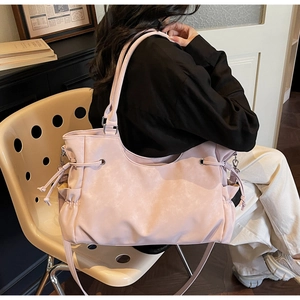 Detail view of pink frosted tote bag featuring functional side drawstring and shoulder strap