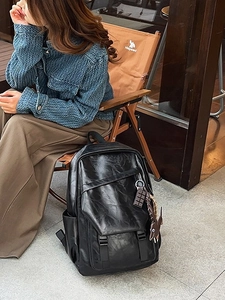 Large black faux leather backpack with buckle straps and vintage texture for travel
