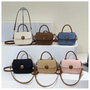 Detalle de bolsos bandolera de colores con hebilla redonda y asas de cuero sintético