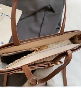 Dettaglio ravvicinato della cerniera in metallo dorato di una borsa a secchiello vintage
