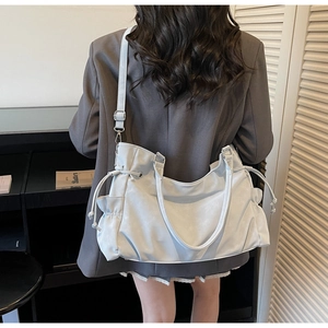 Detail view of large tote bag in matte light blue with side drawstring and adjustable strap