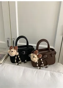 Detail of mini leather crossbody bags with plush bear charms and star bead accessories